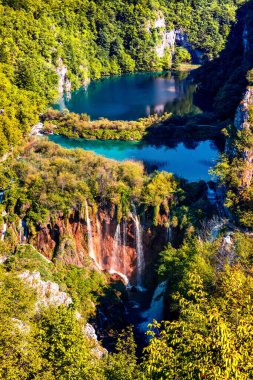 Plitvice Ulusal Parkı 'nın dikey panoramik görüntüsü. Saf su gölleri ve şelaleleri olan yeşil ormanın renkli bahar manzarası. Hırvatistan ve Avrupa 'nın harika kırsal manzarası. Doğa konseptinin güzelliği