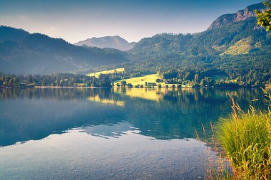 Grundlsee Gölü 'nde güneşli bir sabah manzarası. Avusturya 'nın Liezen Bölgesi, Gessl köyünün güzel yaz manzarası, Alpler. Avrupa. İşlenmiş fotoğraf sonrası sanatsal stil.