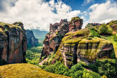 Meteora 'daki güneşli bahar sahnesi, UNESCO Dünya Mirası sitesi. Kaya sütunlarının üzerine inşa edilmiş Doğu Ortodoks manastırlarının rengarenk sabah manzarası. Kalambaka köyünün yeri, Yunanistan, Avrupa.