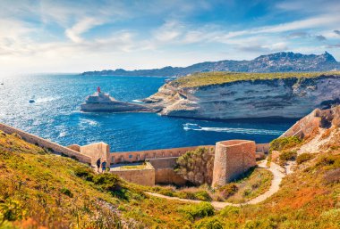 Arka planda Madonetta Deniz Feneri 'nin olduğu Bonifacio eski kalesinin çekici sabah manzarası. Korsika adası, Fransa, Avrupa 'nın nefes kesici yaz manzarası. Güneşli Akdeniz manzarası.