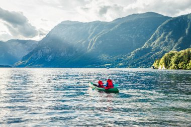 Bir çift kanoyla kürek çekiyor. Bohinj Gölü 'nün harika yaz manzarası, Triglav Ulusal Parkı. Slovenya, Julian Alps 'in güneşli sabah manzarası. Macera, seyahat, eylem, yaşam tarzı kavramı.