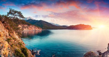 Türkiye 'de resim gibi Akdeniz manzarası. Antalya 'nın Kemer ilçesi yakınlarındaki Tekirova köyünde dramatik bir gündoğumu. İşlenmiş fotoğraf sonrası sanatsal stil.