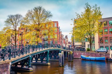 Amsterdam şehrinin büyüleyici sonbahar sahnesi. Meşhur Hollanda kanalları ve harika şehir manzarası. Hollanda, Avrupa 'da kasvetli bir sabah manzarası. Seyahat konsepti arka planı.