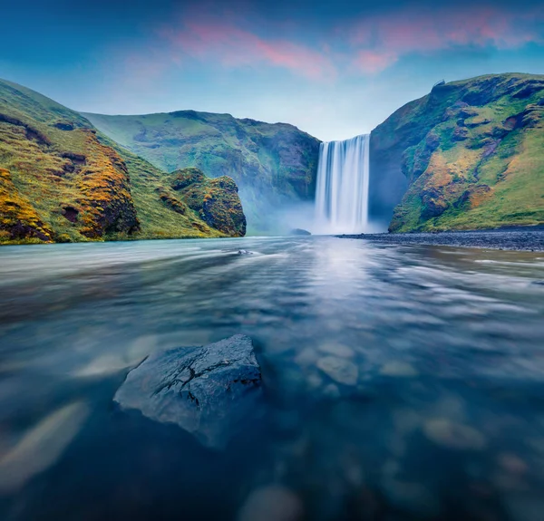 Skogafoss Şelalesi 'nin nefes kesici sabah manzarası. Skoga nehrinde şaşırtıcı bir yaz gündoğumu. Avrupa, İzlanda 'nın kasvetli açık hava manzarası. Doğa konseptinin güzelliği.