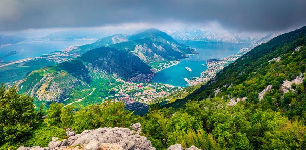 Few minutes before a rain but the mountain slopes are still lighted by the sunlight. Dramatic summer cityscape of Kotor port. Aerial morning view of Kotor bay, Montenegro, Europe.