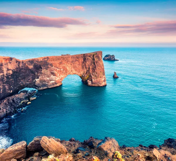 Dyrholaey kemerinin harika akşam sahnesi. İzlanda 'nın güney kıyısındaki Dyrholaey Doğa Koruma Alanı' nda renkli bir yaz günbatımı. İşlenmiş fotoğraf sonrası sanatsal stil.