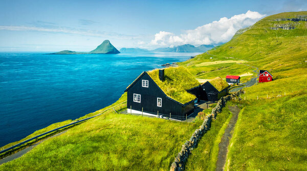 View from flying drone. Dramatic summer view of Velbastadur village with typical turf-top houses. Wonderful morning scene of Streymoy island, Faroe, Denmark, Europe. 