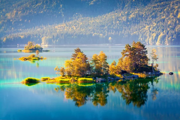 Eibsee gölünde güneş ışığıyla parlayan renkli bir ada. Alman Alpleri, Bavyera, Garmisch-Partenkirchen köyü, Almanya, Avrupa 'da muhteşem bir açık hava sahnesi. İşlenmiş fotoğraf sonrası sanatsal stil.