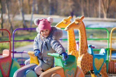 Atlıkarınca üzerinde sevimli küçük kız