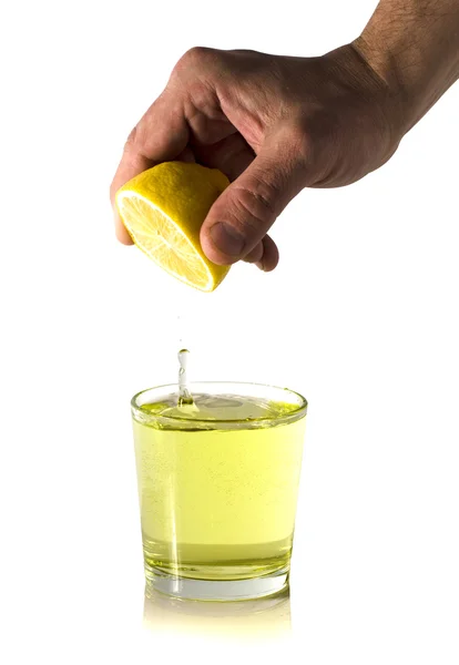 Hand squeezes the juice from the lemon into a glass — Stock Photo, Image