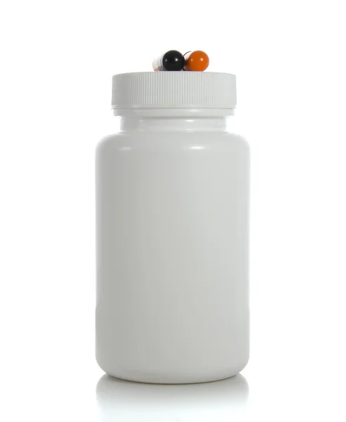 Two pills of a black and orange colors with white jar — Stock Photo, Image