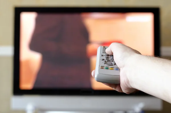 hand with a TV remote control