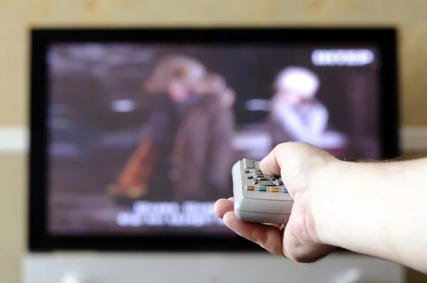 hand with a TV remote control