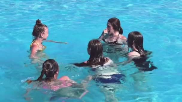 年轻女人和四个少女在游泳池里玩得很开心一群快乐的女孩在游泳池里玩乐和嬉戏 — 图库视频影像