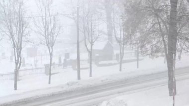 Kışın yoğun kar altında bir şehir. Gün boyunca şehirde karlı bir yol var.. 