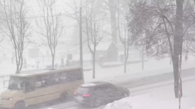 Kışın yoğun kar altında bir şehir. Gün boyunca şehirde karlı bir yol var.. 