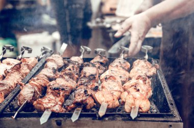Izgarada barbekü. Barbekü ızgarasında et pişiren tanınmamış bir adam. Kapat..