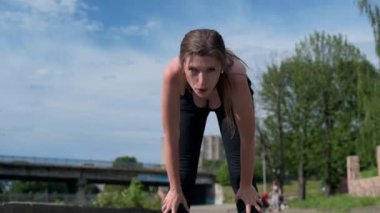 Genç kadın şehir caddesinde koştuktan sonra dinleniyor. Spor yaptıktan sonra dinlenen çekici bir kadın. Fitness, spor ve sağlıklı yaşam tarzı kavramı
