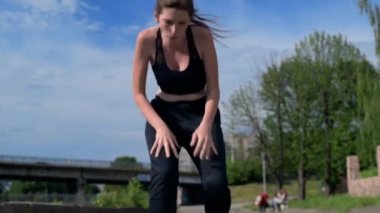 Genç kadın şehir caddesinde koştuktan sonra dinleniyor. Spor yaptıktan sonra dinlenen çekici bir kadın. Fitness, spor ve sağlıklı yaşam tarzı kavramı