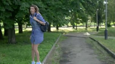 Parkta dans eden genç bir kadın. Parkta dans eden neşeli bir kadın. Güzel bir kadın doğanın tadını çıkarıyor.