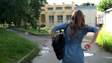 Genç bir kadın sokakta yürüyor, zıplıyor ve eğleniyor. Bayan model tatilde eğleniyor. Yavaş çekim