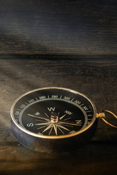 Kompas Ciemnym Drewnianym Tle Promieniami Światła Obraz Pionowy — Zdjęcie stockowe