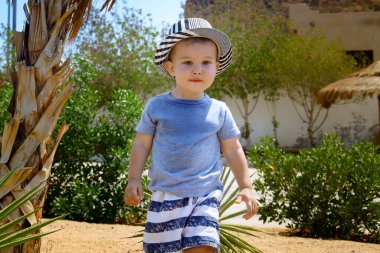 Tatil köyündeki genç çocuğun portresi. Mısır 'daki otelin yanındaki çocuk. Egzotik bir plajda üstsüz genç bir çocuk.