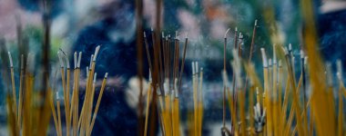 Budist tapınağında tütsü çubukları var. Tütsüden çıkan duman ve yanan çubuklar.