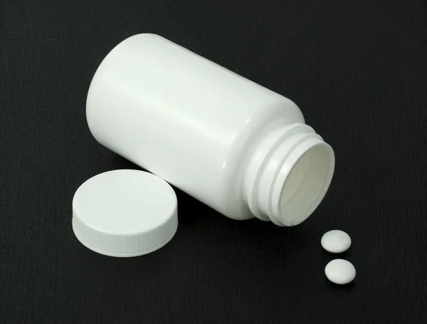 Duas pílulas brancas com frasco branco — Fotografia de Stock