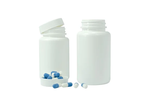 Some pills of a white and blue colors with two white jar — Stock Photo, Image