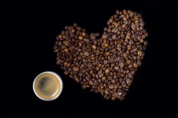 Cup of coffee and the heart of the coffee beans — Stock Photo, Image