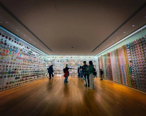 Turistler Japonya 'nın Yokohama kentindeki Cup Noodles Müzesi' nde cam bir sergiye bakıyorlar..