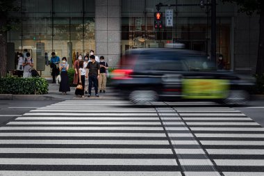 Tokyo, Japonya 'da bir kavşaktan geçmek için taksi bekleyen insanlar..