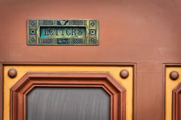 The mail slot for letters on a door in Osaka, Japan.