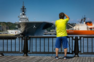 Japonya 'nın Yokosuka kentindeki Verny Park' ta rıhtımdaki gemilerin fotoğraflarını çeken bir fotoğrafçı..