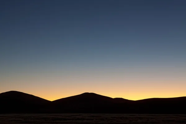 Woestijn zonsopgang met silhouetten van zandduinen — Stockfoto