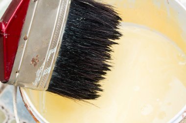 Boyanmış eski fırça boya kovasına batıyor..