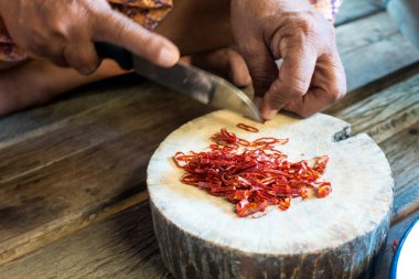 Kesme tahtasında kırmızı biberler kesilir.