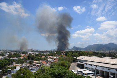 Rio de Janeiro, Brezilya, 20 Ekim 2020. Boş arazide çöp yakmak Rio de Janeiro 'nun batısındaki Jacarepagu mahallesinde büyük bir duman yaratıyor.