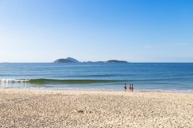Rio de Janeiro / Brezilya - Aralık 2019: Ipanema plajı, sabah. Sahile doğru yürüyen bir grup kadın. Ufuktaki Ilhas Cagarras adaları.