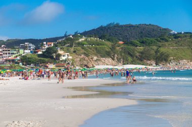 ARRAIAL DO CABO, RIO DE JANEIRO, BRAZİL - 26 Aralık 2019 Praia Grande plajının panoramik manzarası. Beyaz kum, berrak ve şeffaf deniz suyu. Bazı insanlar güneşli günün tadını çıkarıyorlar. Arkaplanda tepeler.