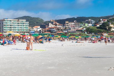 ARRAIAL DO CABO, RIO DE JANEIRO, BRAZİL - 26 Aralık 2019: Praia Grande plajı manzarası. Beyaz kum, berrak ve şeffaf deniz suyu. Bazı insanlar güneşli günün tadını çıkarıyorlar. Arkaplanda tepeler.