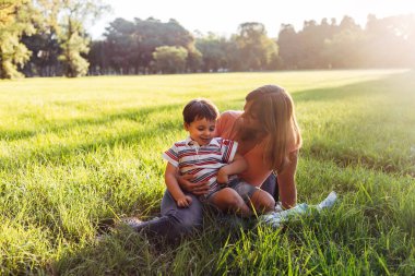 Anne ve oğlu gün batımında parkta..