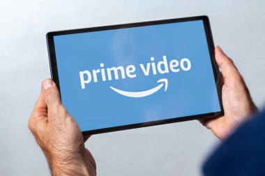 ROSARIO, ARGENTINA - 11 Mart 2021: Ekranda ana video yayını servis logosu olan bir tablet tutan adam.