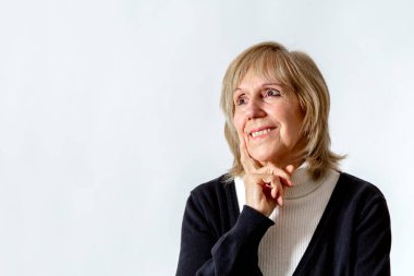 Bir fikrim var. Düşünme pozisyonunda yaşlı bir kadın. Yüzünde eli olan. Beyaz arka plan. 65 yaşlarında bir kadın..