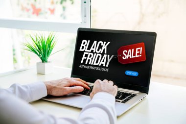 Kara Cuma anlaşmaları. Bilgisayarlı bir adam internetten indirimli bir ilan gösteriyor..