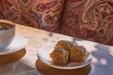 Doğu tatlılığı, Türk baklavası, eski ahşap bir masada gölgeli beyaz bir fincanda taze siyah kahve..