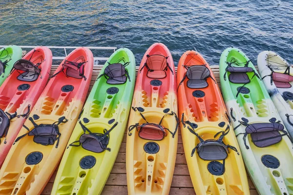 Számos Sokszínű Műanyag Kajak Csónak Egy Fából Készült Színpadon Tenger — Stock Fotó