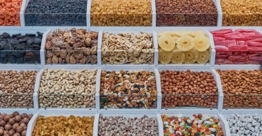 Kafkasya ya da Orta Asya 'nın otantik bir tatil köyünde kurutulmuş meyve ve fındık dolu bir tezgah. Pankart