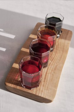 Tahta tahtadaki su bardaklarında dört yumurta mora, pembeye, turuncuya, yeşile boyanıyor. Paskalya tatili konsepti